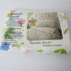 May include: A white packaging with a floral design and the text "Vamsutta ultracale" and "Wildflower Composé". The packaging shows a white bed with a floral patterned bedspread.