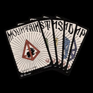 Puede incluir: Un abanico de cinco cartas de juego sobre un fondo negro. Las cartas presentan la palabra "MOUNTAINS" en una fuente estilizada. Cada carta tiene un fondo color crema con una forma geométrica y un color diferente. El texto "BASIC LAND" está en la parte inferior.