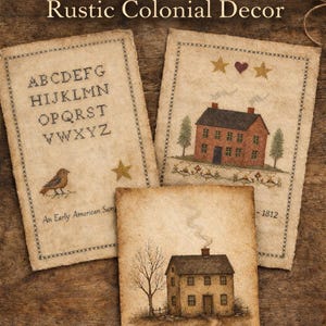 May include: Three Early American sampler prints with rustic colonial decor. The prints feature cross-stitch designs of a house, a bird, and the alphabet. The prints are on aged paper with decorative stitching around the edges.