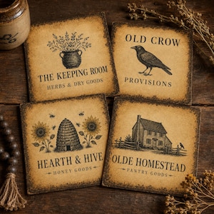 Puede incluir: Cuatro posavasos cuadrados con un acabado beige envejecido e ilustraciones en tinta negra. Los diseños incluyen una planta en maceta etiquetada como The Keeping Room, un cuervo como Old Crow Provisions, una colmena con girasoles como Hearth & Hive y una casa como Olde Homestead.