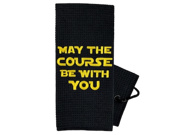 May include: Black golf towel with a yellow embroidered saying "May the course be with you."