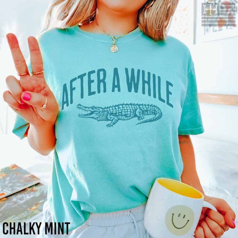 Funny 'After a While, Crocodile' t-shirt with playful crocodile graphic, perfect for fans of humorous, sarcastic, and novelty tees. Great gift for Mother's Day or anyone who loves witty sayings, Comfort Colors Chalky Mint Shirt