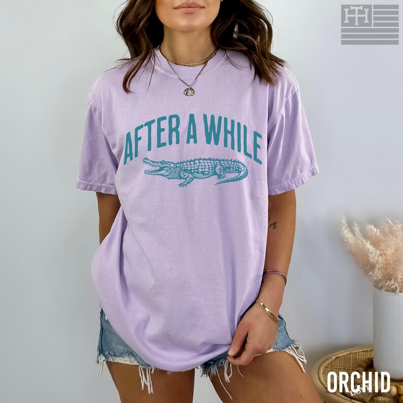 Funny 'After a While, Crocodile' t-shirt with playful crocodile graphic, perfect for fans of humorous, sarcastic, and novelty tees. Great gift for Mother's Day or anyone who loves witty sayings, Comfort Colors Orchid shirt