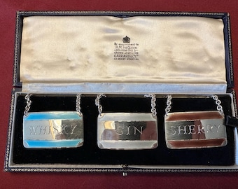 English Sterling and Enamel liquor bottle labels - GARRARD @ Co. jewelers to the Queen.
