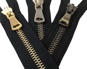 May include: Three black zipper tapes with different colored metal zipper pulls. The zipper pulls are gold, silver, and gunmetal.