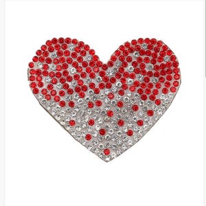 May include: A red and white heart-shaped rhinestone embellishment. The heart is covered in small, round rhinestones, with red rhinestones clustered at the top and bottom.