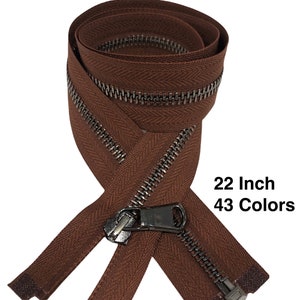 Puede incluir: Una cremallera marrón de 56 cm con un deslizador de metal plateado. La cinta de la cremallera tiene un patrón de espiga. 43 Colores.