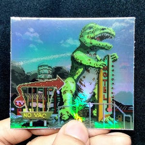 May include: Square holographic sticker featuring a pixelated green Tyrannosaurus Rex holding a sign that says "NO VAC". The background includes a motel and a sunset. The sticker is held by a hand.