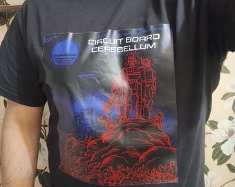 May include: Black t-shirt with a graphic print of two robots standing on a pile of red and blue objects. The text "CIRCUIT BOARD CEREBELLUM" is printed on the graphic.