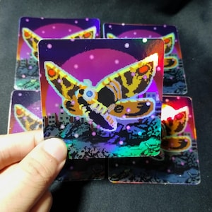 May include: A set of five holographic stickers featuring a pixelated moth with red, yellow, and black wings against a purple and blue background. The moth is flying over a cityscape.