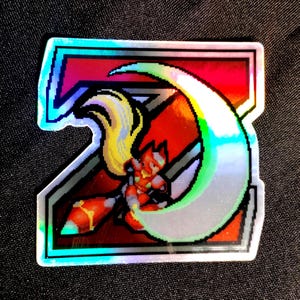May include: A holographic sticker featuring a large, bold, pixelated letter Z with a red and black gradient fill. Inside the letter, a pixelated character with long blonde hair and red armour holds a glowing crescent-shaped energy blade.