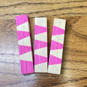 Op de afbeelding: Drie houten blanco's met een roze en wit gestreept patroon. De blanco's zijn ongeveer 7,6 cm lang en 2,5 cm breed.
