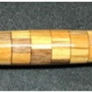 May include: A wooden pen with a unique design featuring multiple shades of brown and beige wood. The pen is made of wood that has been cut into small squares and then arranged in a pattern.