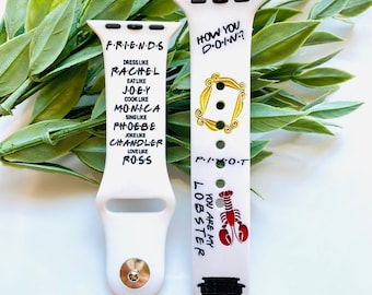 May include: Two white watch bands with black text and graphics. One band says "FRIENDS" and lists character traits. The other says "HOW YOU DOIN?" and "YOU ARE MY LOBSTER" with a red lobster graphic.
