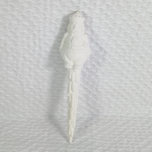 May include: A white, ceramic Christmas ornament shaped like a nutcracker soldier. The ornament has a detailed design, including a crown, uniform, and a textured base. The ornament is approximately 7 inches tall.