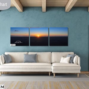 Waves form a curtain from horizon to horizon as the sunset creates a spectacular, colorful display of oranges, and yellows as it sets over Playa Tamarindo, Costa Rica. A 24x72 inch print hangs above a sectional sofa for perspective.