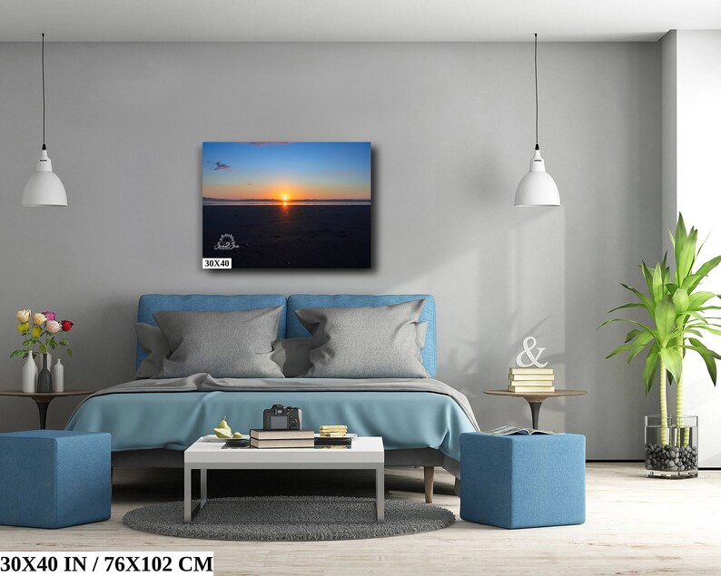 Waves form a curtain from horizon to horizon as the sunset creates a spectacular, colorful display of oranges, and yellows as it sets over Playa Tamarindo, Costa Rica. A 30x40 inch print hangs above a bed for perspective.