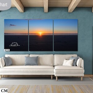 Waves form a curtain from horizon to horizon as the sunset creates a spectacular, colorful display of oranges, and yellows as it sets over Playa Tamarindo, Costa Rica. A 40x90 inch print hangs above a sectional sofa for perspective.