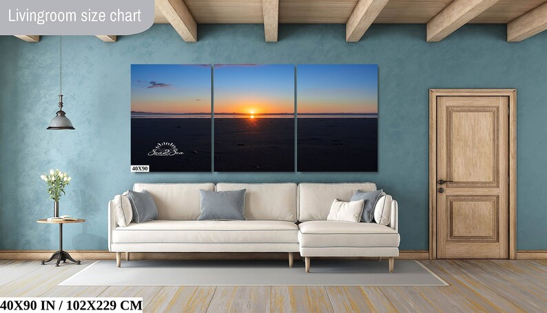 Waves form a curtain from horizon to horizon as the sunset creates a spectacular, colorful display of oranges, and yellows as it sets over Playa Tamarindo, Costa Rica. A 40x90 inch print hangs above a sectional sofa for perspective.
