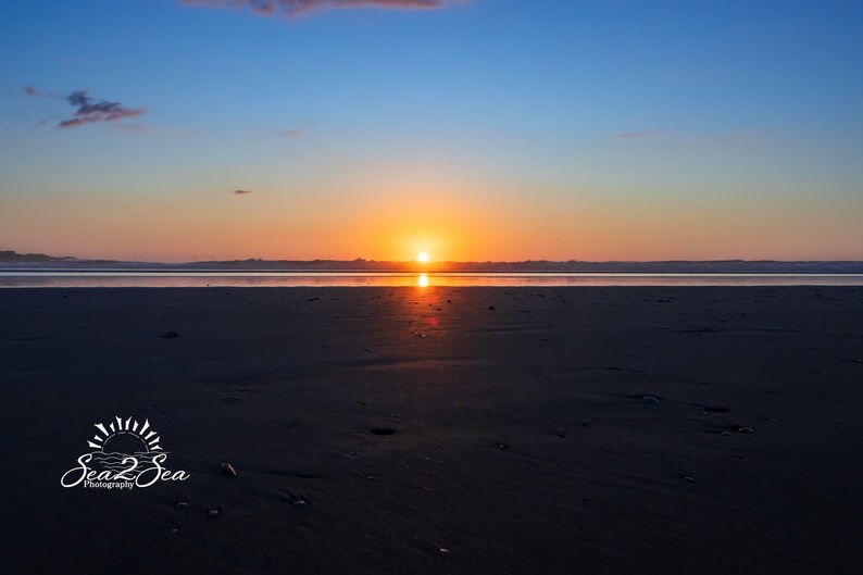 Waves form a curtain from horizon to horizon as the sunset creates a spectacular, colorful display of oranges, and yellows as it sets over Playa Tamarindo, Costa Rica. This wall art is available in glossy photo prints, or canvas.