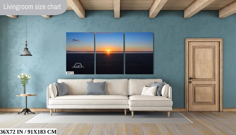 Waves form a curtain from horizon to horizon as the sunset creates a spectacular, colorful display of oranges, and yellows as it sets over Playa Tamarindo, Costa Rica. A 36x72 inch print hangs above a sectional sofa for perspective.