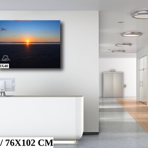 Waves form a curtain from horizon to horizon as the sunset creates a spectacular, colorful display of oranges, and yellows as it sets over Playa Tamarindo, Costa Rica. A 30x40 inch print hangs above an office reception desk for perspective.