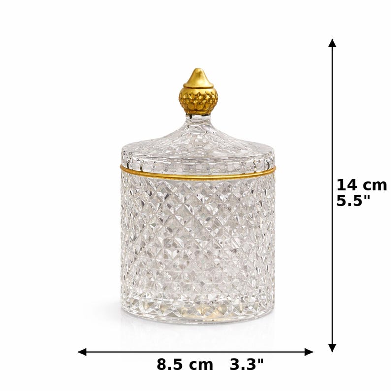 K&ouml;nnte beinhalten: Ein klares Glasgef&auml;&szlig; mit Rautenmuster, einem goldenen Rand und einer goldenen Spitze auf dem Deckel. Das Gef&auml;&szlig; ist 14 cm hoch und 8,5 cm breit. F&uuml;r dekorative Zwecke.