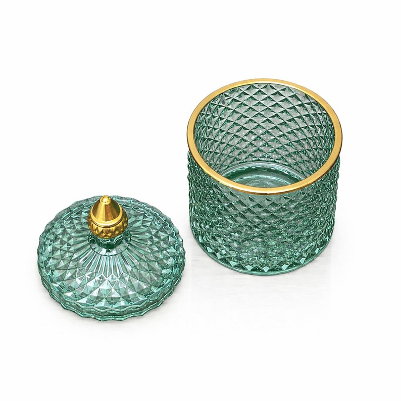 K&ouml;nnte beinhalten: Ein teal-farbenes Glasgef&auml;&szlig; mit Rautenmuster und goldenem Rand. Der Deckel, mit einem goldenen Knauf, liegt daneben. Das Gef&auml;&szlig; dient zur Aufbewahrung und Dekoration. Die Ma&szlig;e sind in Zentimetern.