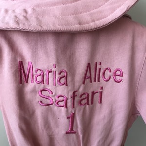 K&ouml;nnte beinhalten: Rosa Safari-Jacke mit gesticktem Text "Maria Alice Safari 1" auf der R&uuml;ckseite.