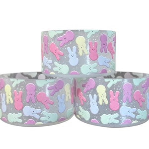 May include: Three pastel-colored ceramic bowls with a speckled glaze and a repeating pattern of pastel-colored bunny shapes.