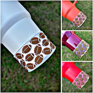 May include: Four different color tumblers with a white and brown football pattern around the top edge. The tumblers are white, orange, burgundy, and red.