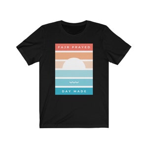 May include: Black t-shirt with a graphic design of a sunset with the text "FAJR PRAYED" and "DAY MADE" in a rectangle.