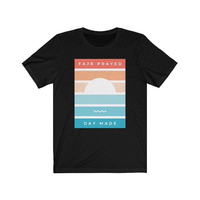 May include: Black t-shirt with a graphic design of a sunset with the text "FAJR PRAYED" and "DAY MADE" in a rectangle.