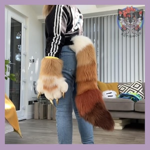 May include: A furry costume set featuring a pair of paw-shaped gloves and a long tail. The gloves are tan with white and gold claws. The tail transitions from white to tan, then to brown. The set is designed for cosplay or costume use.