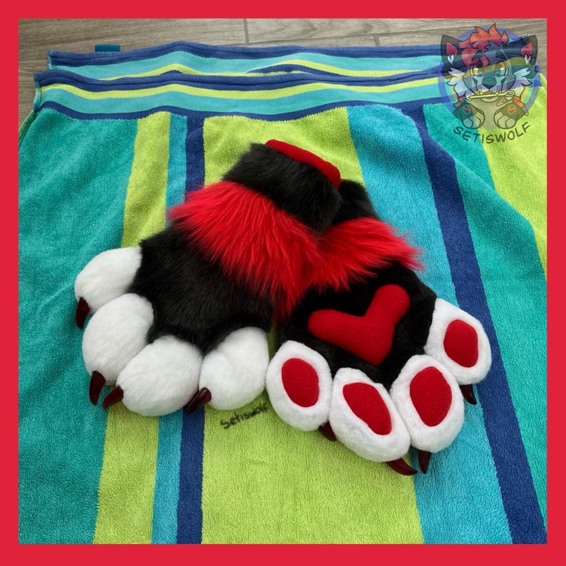 May include: A pair of plush paw gloves featuring black and red faux fur, white paw pads, and dark red claws. The gloves include a prominent red heart-shaped patch on the back of one hand and a small logo text reading Setiswolf on the fabric.