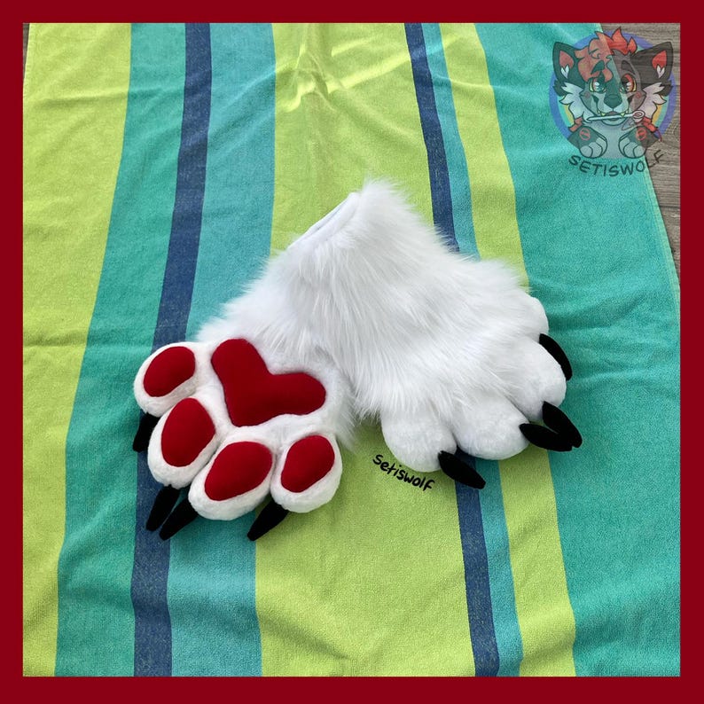 May include: A pair of white faux fur animal paw gloves featuring plush red heart-shaped and oval-shaped paw pads with black claws. The text Setiswolf is visible on the paw and in the top right corner logo, which depicts a stylized wolf character.