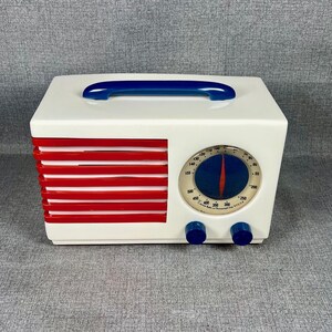 Pode incluir: Um temporizador de cozinha retr&ocirc; branco com uma al&ccedil;a e bot&otilde;es azuis. O temporizador apresenta um design vermelho e branco na lateral e um mostrador azul e branco com uma agulha indicadora vermelha. Um acess&oacute;rio de cozinha vintage.