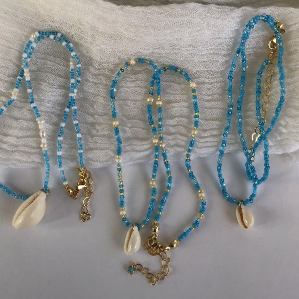 Collier ras de cou bohème de perles bleues et blanches avec un pendentif coquillage cauri: bijou fait main bijou de plage d’été pour femme