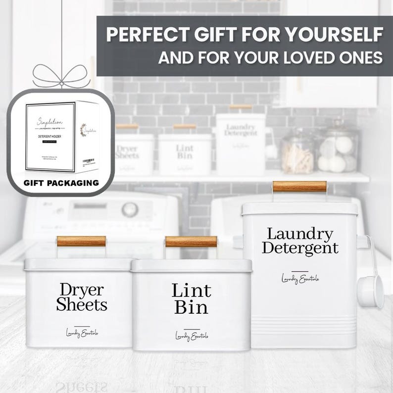 May include: Three white metal containers with wooden handles and black labels. The containers are labeled "Laundry Detergent", "Dryer Sheets", and "Lint Bin". The containers are on a white surface in front of a white tiled wall.