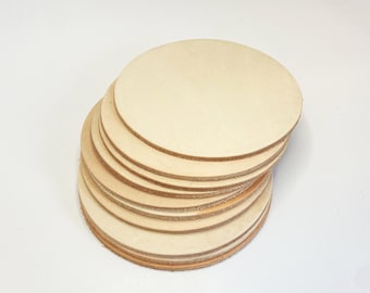 May include: A stack of round, cream-colored leather coasters.