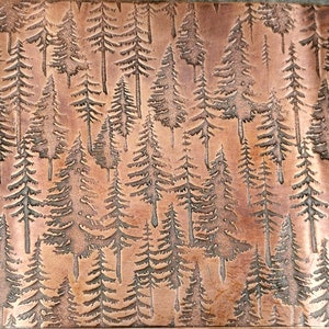 May include: A copper-toned metal panel with an embossed forest design. The panel is covered in detailed evergreen trees of varying sizes, creating a textured, naturalistic pattern. The rectangular panel is reminiscent of a woodland scene.