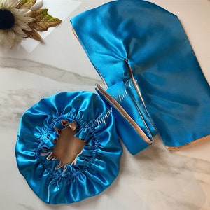 May include: Two turquoise satin hair bonnets, one is a traditional bonnet and the other is a larger bonnet with a slit in the back. Both bonnets have a beige satin lining.