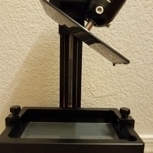 Close-up of Elegoo Mars build plate drain hanger holding the platform at an angle above the resin vat, allowing leftover resin to drip back into the tank after 3D printing, angled resin drain holder for Elegoo Mars, Mars Pro and Mars 3 printers