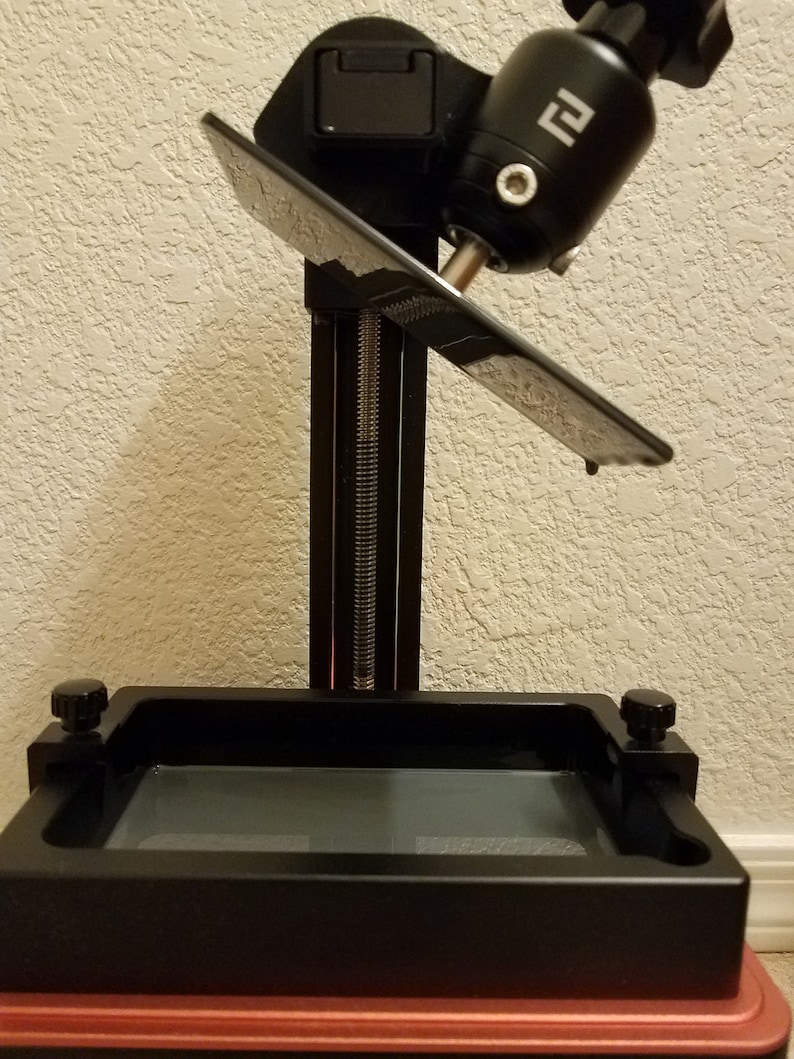 Close-up of Elegoo Mars build plate drain hanger holding the platform at an angle above the resin vat, allowing leftover resin to drip back into the tank after 3D printing, angled resin drain holder for Elegoo Mars, Mars Pro and Mars 3 printers