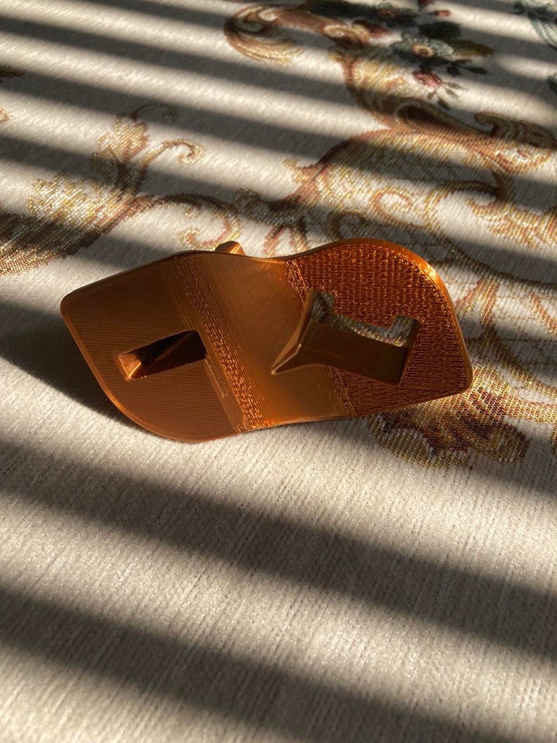 Angled build plate drain hanger for Elegoo Mars resin 3D printer shown in multiple colors, 3D printed resin drip holder accessory designed to hold the build plate at an angle for draining resin back into the vat, compatible with Elegoo Mars, Mars Pro and Mars 3