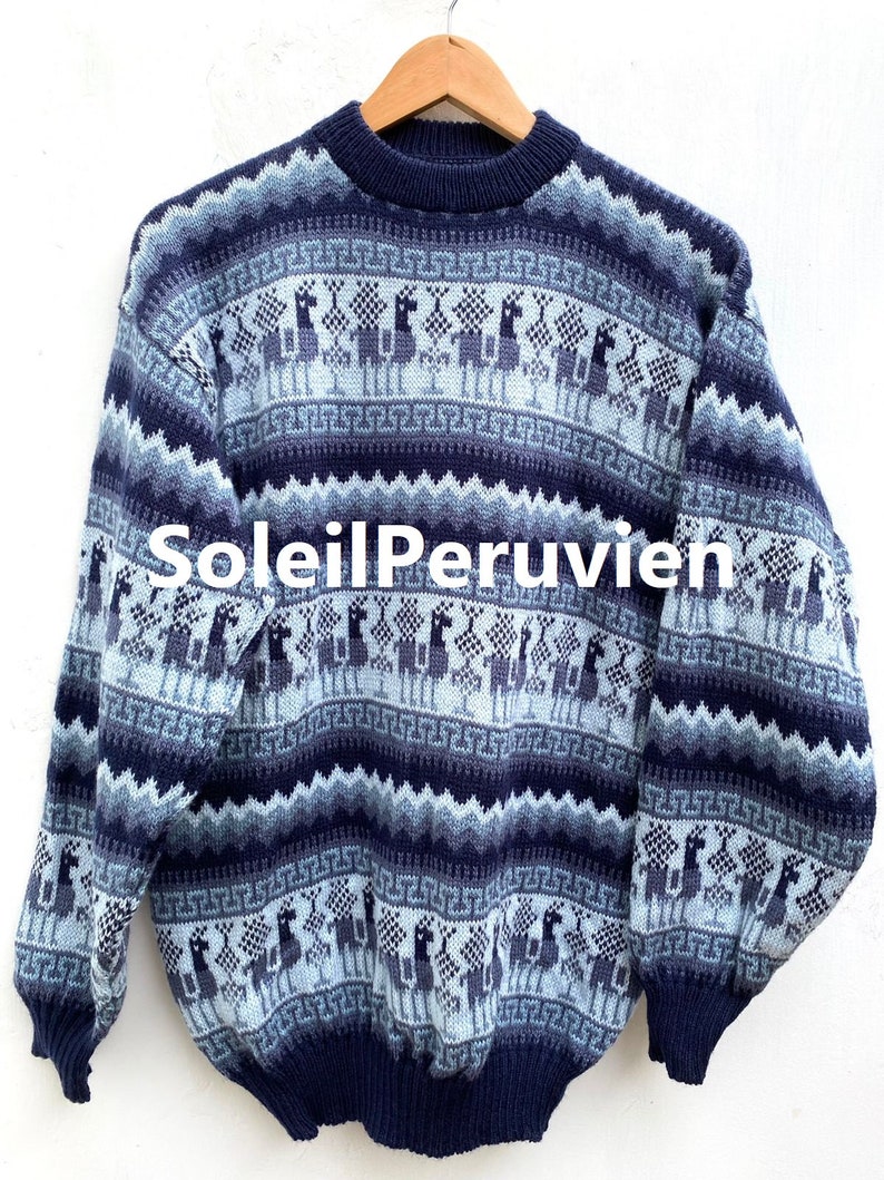 May include: A blue and white alpaca patterned sweater with a crew neck. The sweater is made of a soft, knitted fabric.