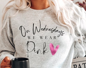 May include: A gray sweatshirt with the text "On Wednesdays We Wear Pink" and a pink heart graphic.