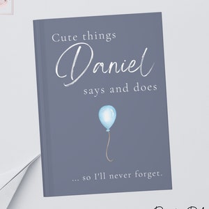 Peut inclure: Une couverture de journal bleu et blanc avec le texte "Cute things Daniel says and does... so I'll never forget." et une illustration de ballon bleu. Le texte "Dusty Blue" est en bas de la couverture.