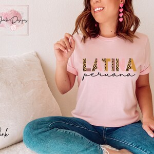 May include: A pink t-shirt with the text "LATINA peruana" in brown, pink, and gold letters with a leopard print pattern.