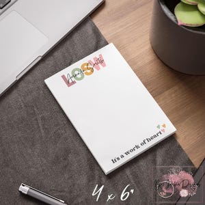 May include: A white notepad with the text "Amanda Smith" in pink, green, and orange, and the words "It's a work of heart." The notepad measures 4 x 6 inches.